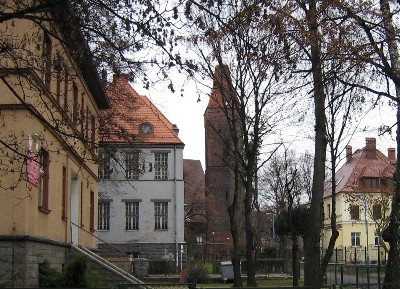 Links vor Gymnasium, Kirchturm und Direktorhaus das arbeitsmedizinische Zentrum in Lubin