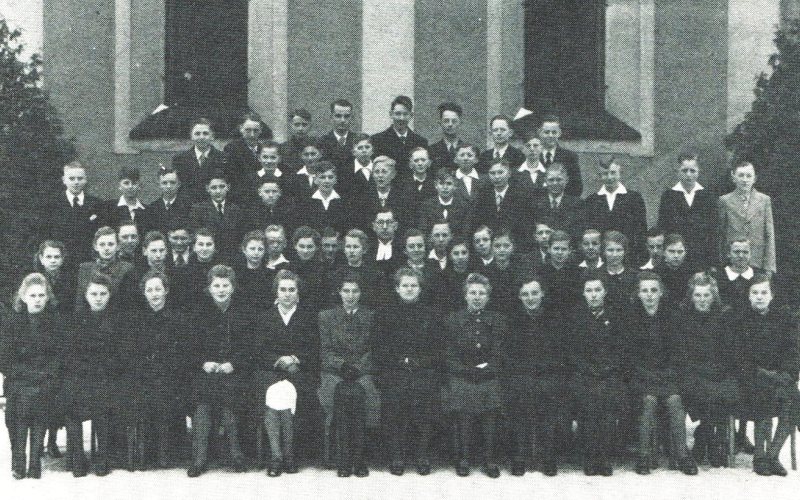 Pfarrer Rudolf Irmler mit seinen Konfirmanden vor der Evangelischen Kirche zu Kotzenau im Jahr 1942